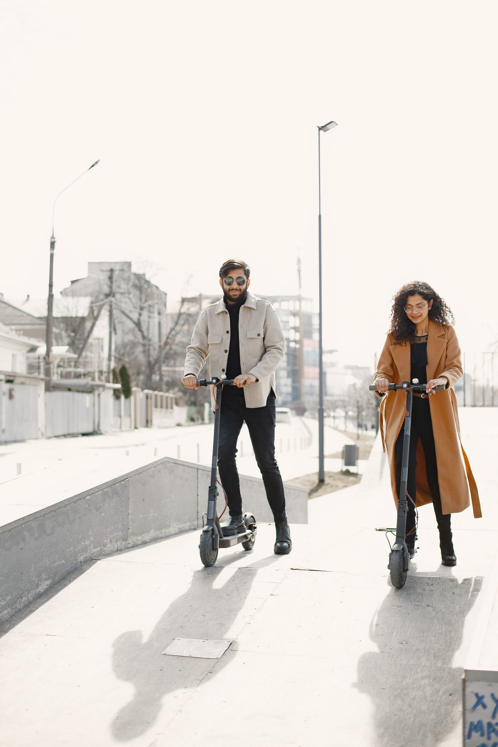Pareja andando en patinetes eléctricos por la ciudad
