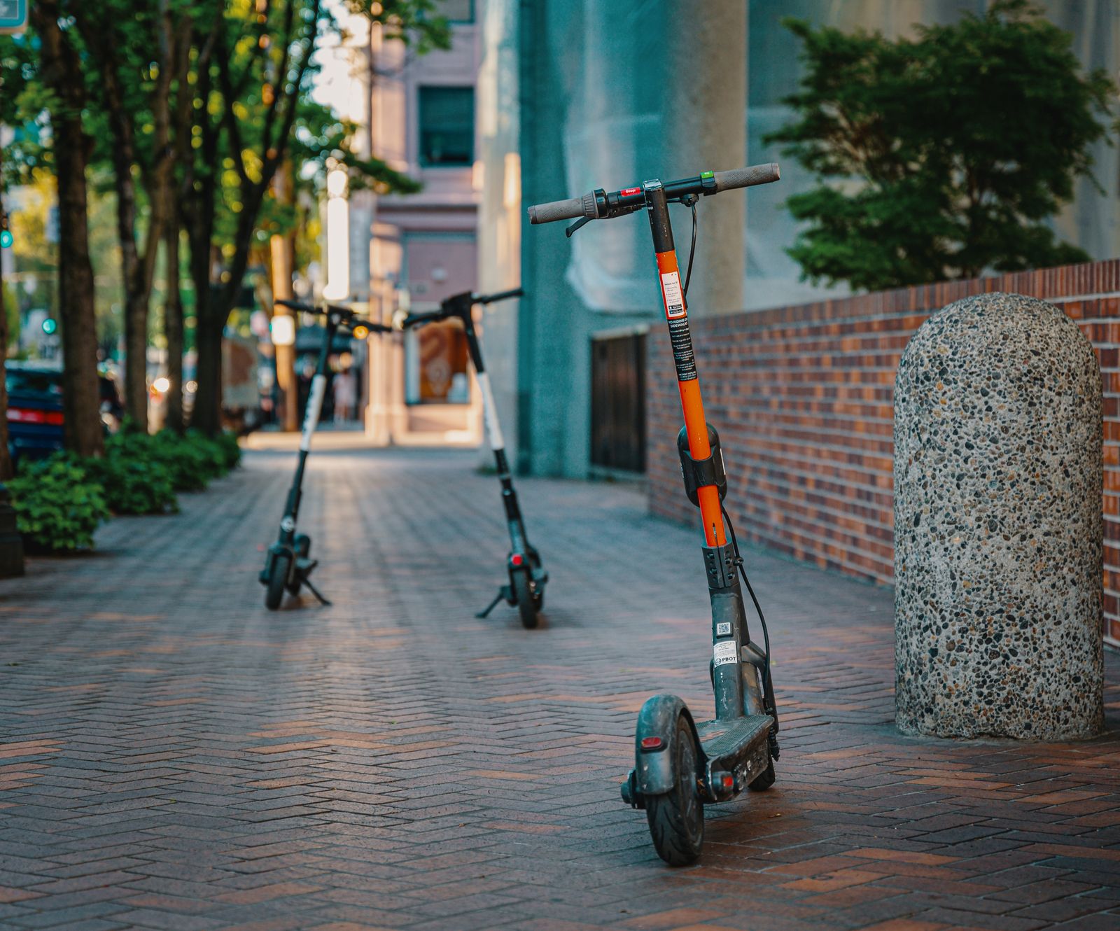 Fila de patinetes eléctricos estacionados en una vereda urbana